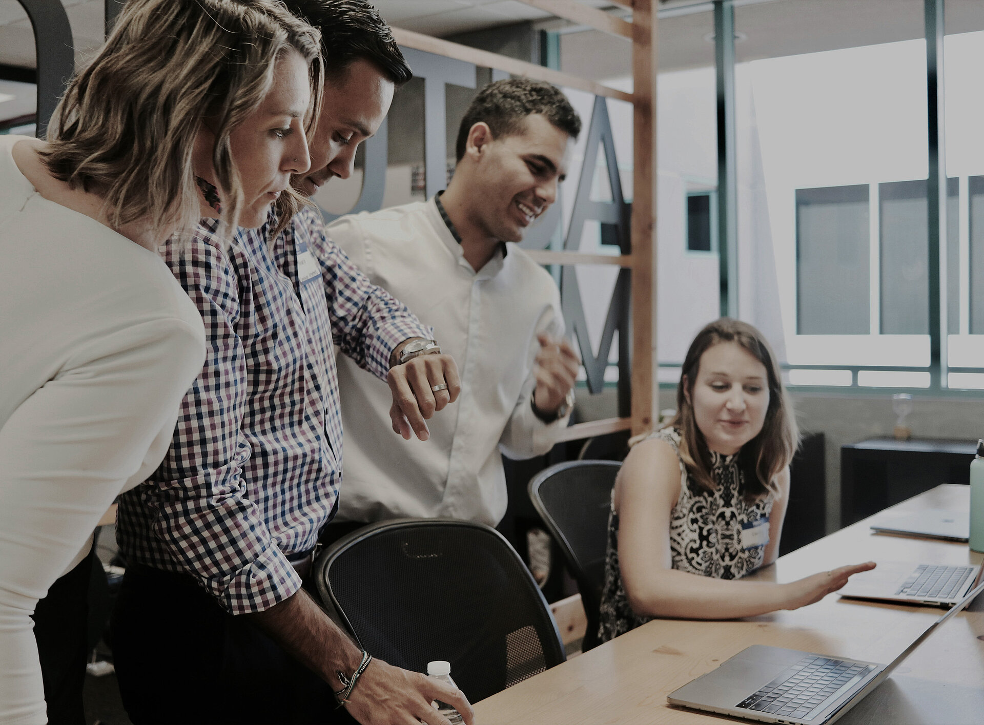 Vier Personen führen ein Gespräch vor einem Laptop