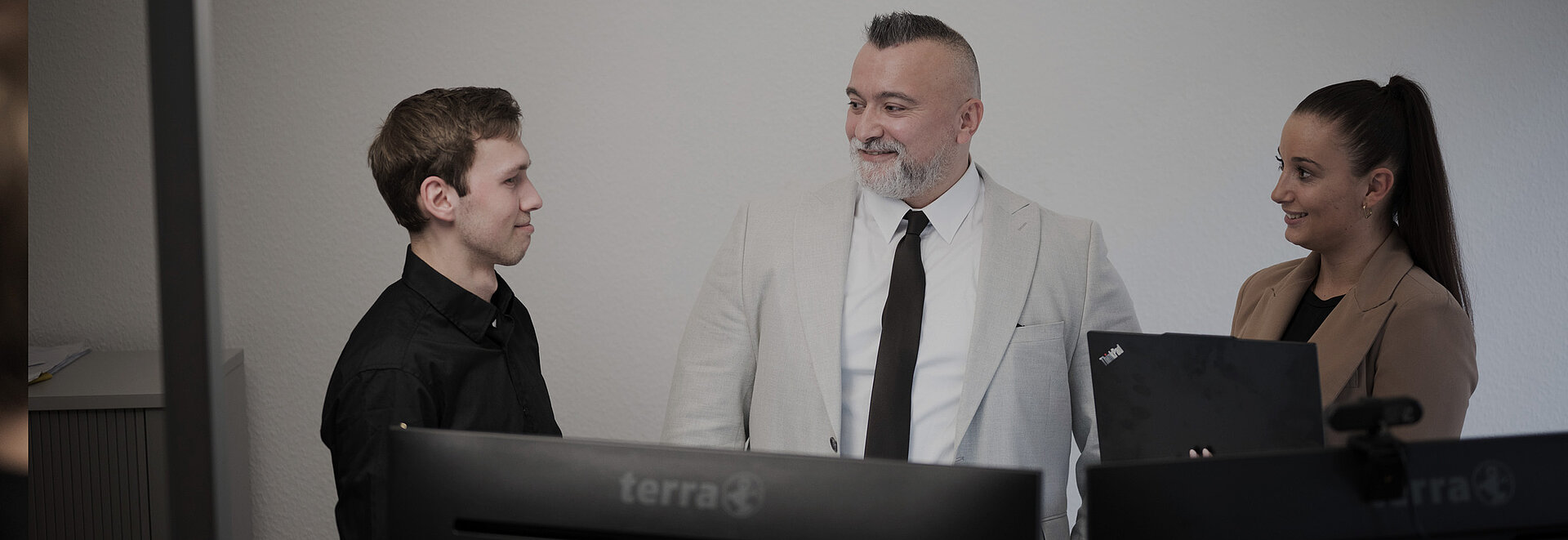 Drei Steuerberater unterhalten sich vor Rechnern