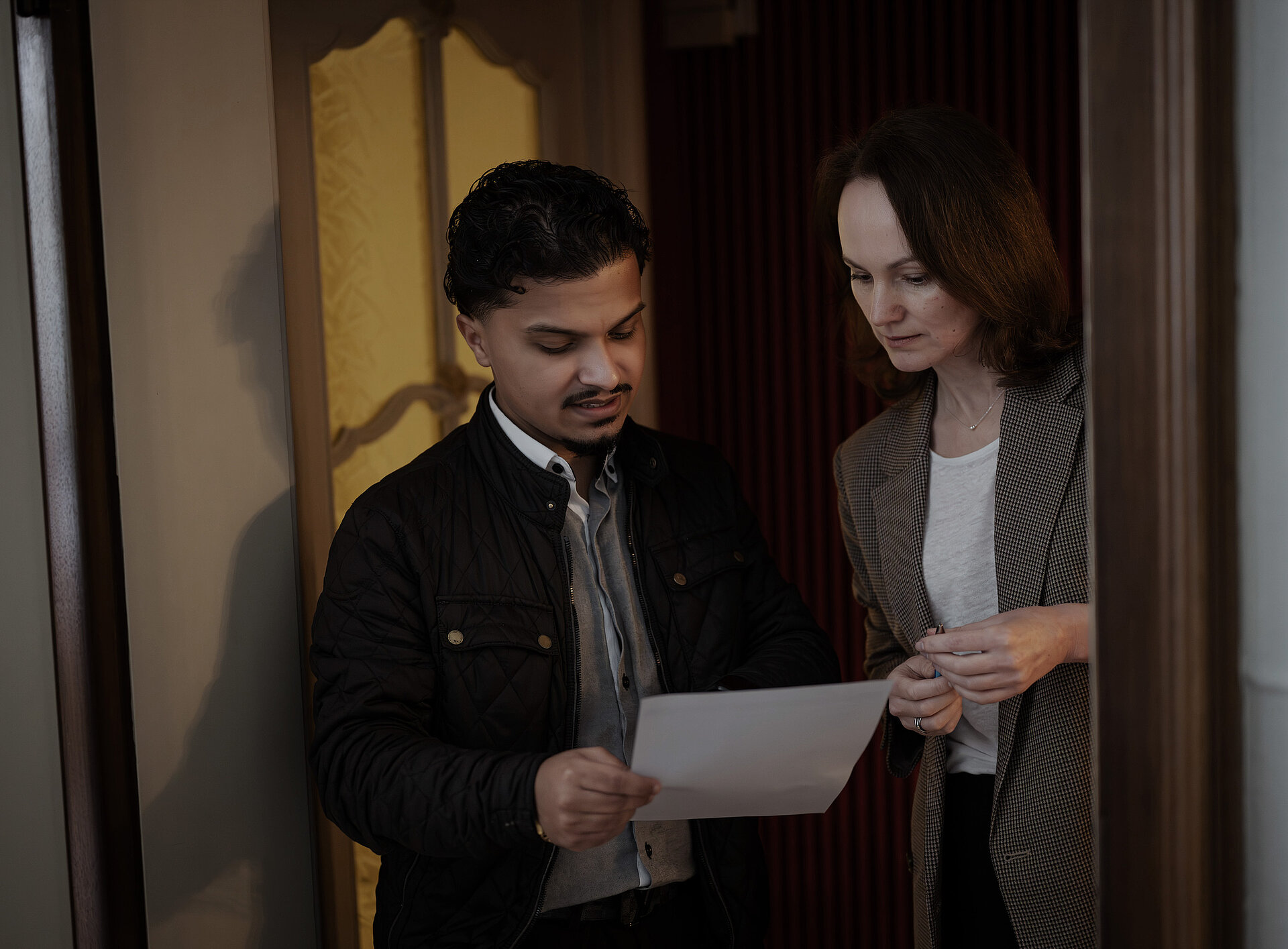 Zwei Personen auf einen Zettel und unterhalten sich