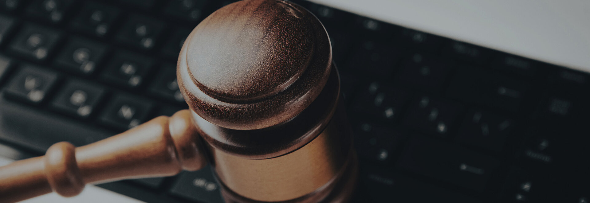 Nahaufnahme einer Tastatur auf der ein Richterhammer liegt