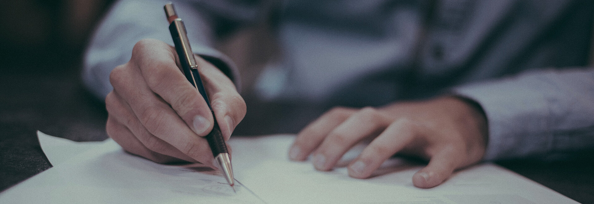 Ein Mann schreibt etwas auf Papier