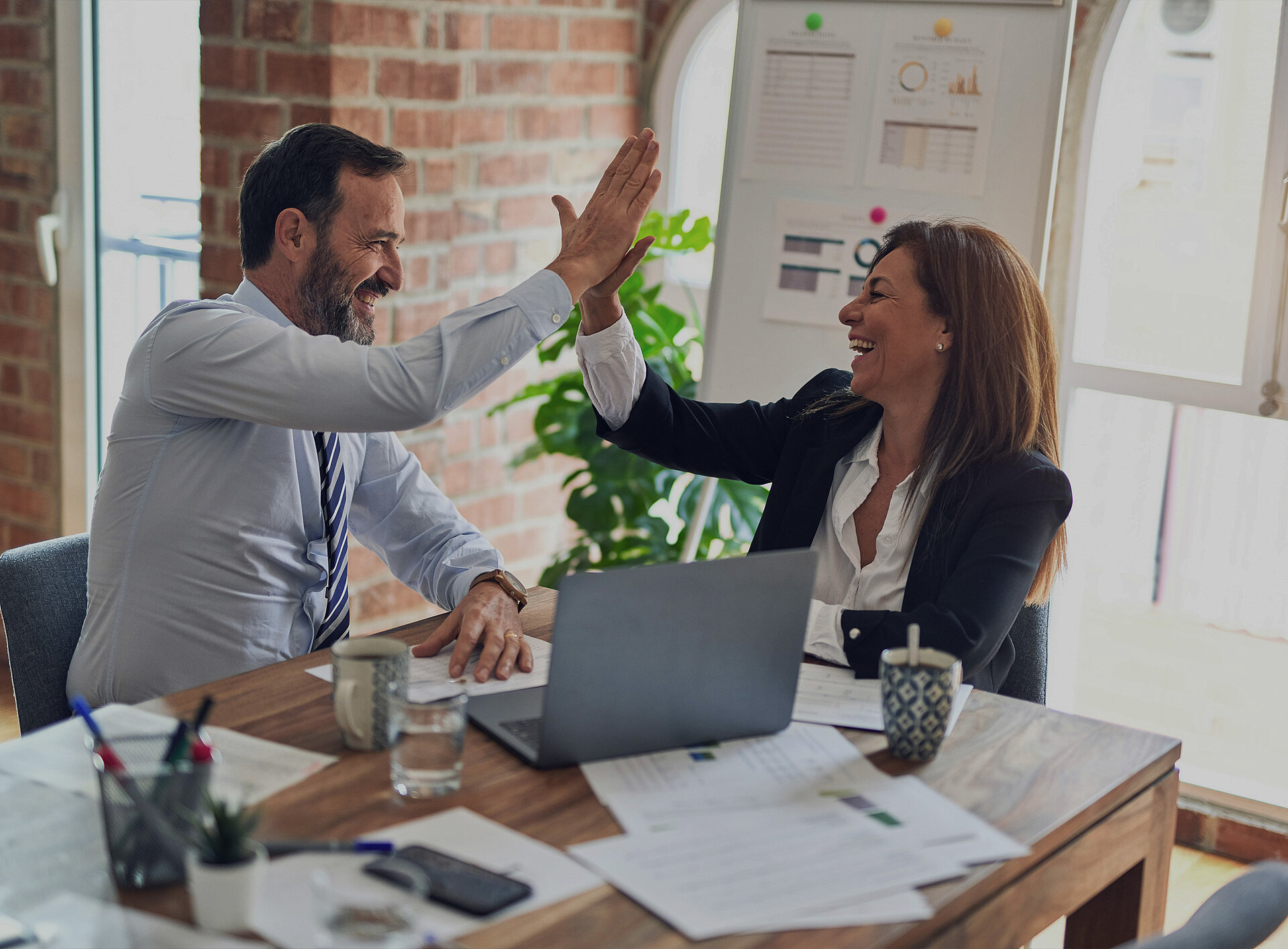 Ein Mann und eine Frau klatschen fröhlich in die Hände