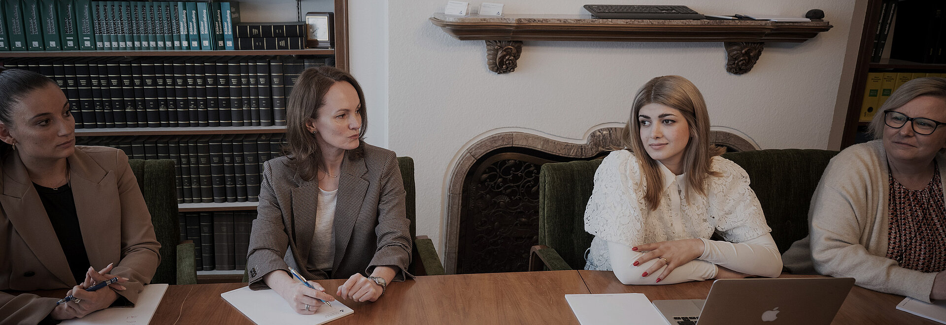 Steuerberater am Tisch versammelt, unterhalten sich.