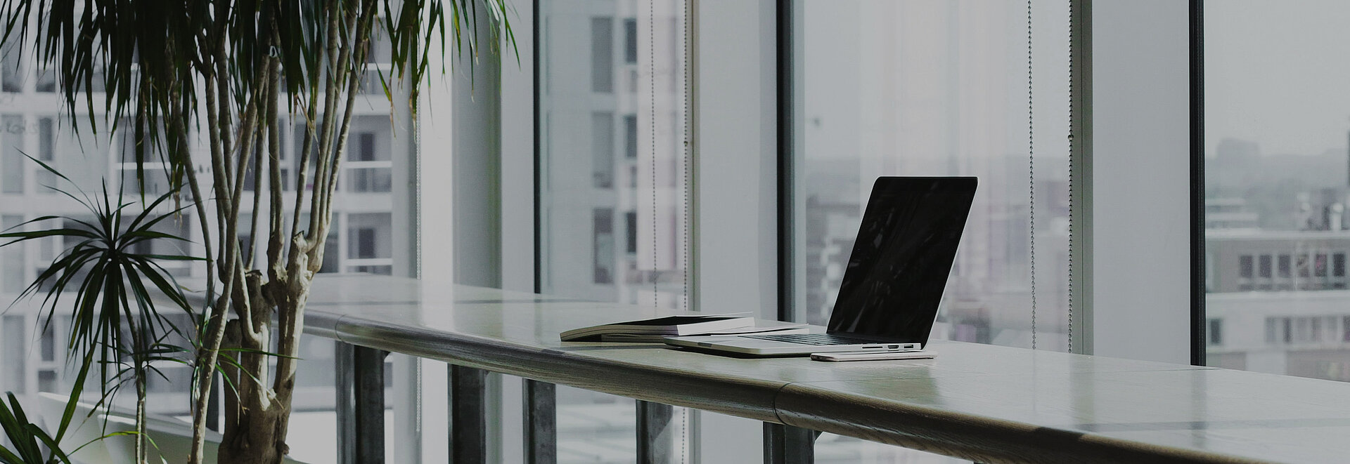 Ein Laptop steht auf einem Schreibtisch in einem hellen Büro