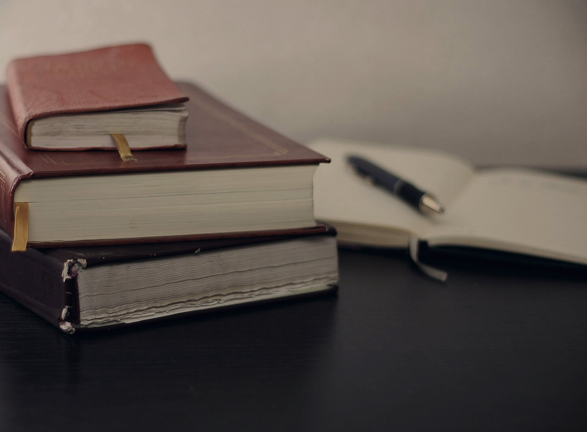 Gestapelte Bücher und ein Notizheft